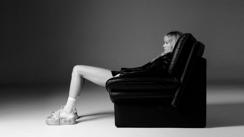 FIRSTCORNER model seated in profile